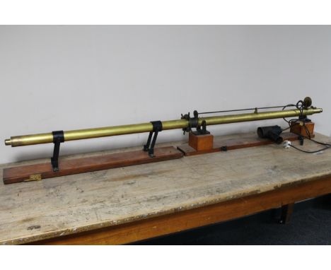 An early 20th century solid brass 6' electric light beam measuring telescope on mahogany base 