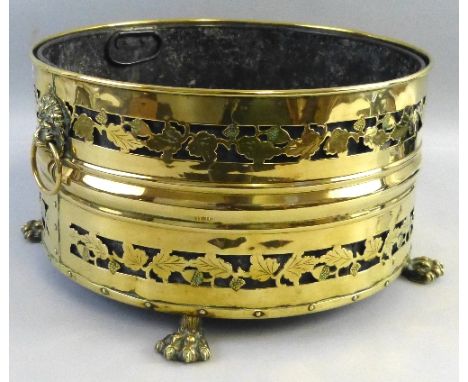 A brass coal bin, of drum shaped form pierced with bands of fruiting vines, two lion mask ring handles and three (ex 4) paw f