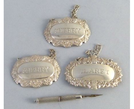 Three decanter labels, each of oval form with embossed border, two inscribed 'Sherry' and one 'Claret', all with suspension c