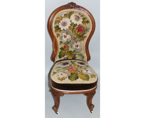 A Victorian walnut nursing chair, the line incised balloon back with carved crest rail, tapestry and needlework upholstery an