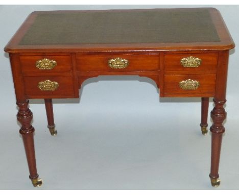 A late Victorian walnut writing table, the rounded oblong top with moulded edge and inset writing surface, over a central fri