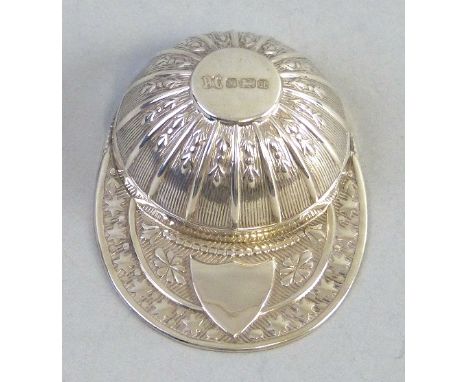 A caddy spoon, in the shape of a jockeys cap with embossed decoration, Sheffield 1982