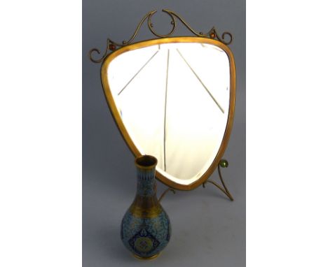 An Arts and Crafts style brass framed easel mirror, of shield shaped form with wire work crest rail, feet and strut support, 