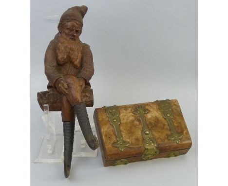 A 19th century black forest carved hardwood figure, of a gnome, wall mounting modelled seated on a log with horn lower legs, 