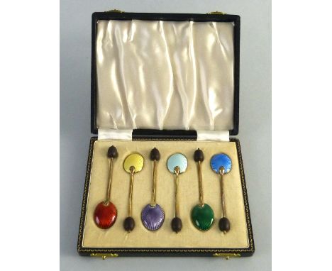 A set of six silver gilt coffee spoons, each with a black bean terminal and different colour enamel bowl back, cased, Birming