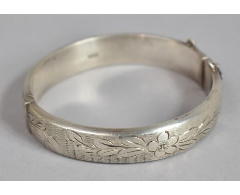 A Silver Bangle, Birmingham 1967 with Safety Chain and Engraved Floral Decoration 