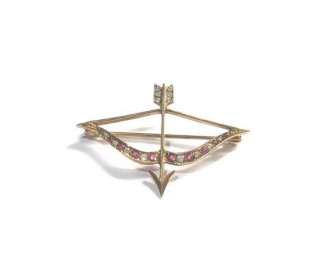 9ct gold bow &amp; arrow brooch set with ruby and white sapphires measures approx 4.2cm by 3cm weight 3.2g 