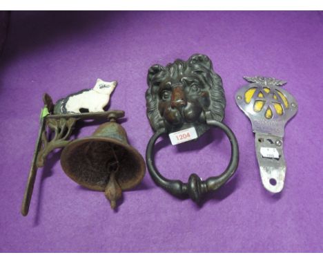 A heavy brass cast door knocker in the form of a loins head