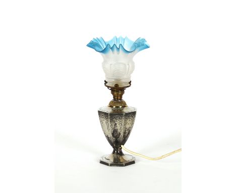 An electro plated vase shaped table lamp, with engraved decoration and blue tinted frilled glass shade