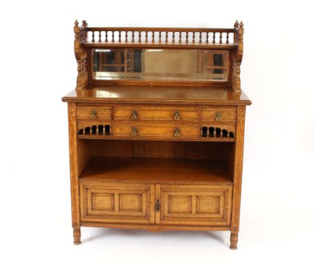 An early 20th Century light oak chiffonier, in the aesthetic movement style, having raised mirrored back shelf, four drawers 