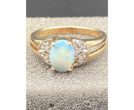 Ladies 9 carat gold ring having faux Opal Solitaire in four claw mount to top with gemstone surround.3.2 grams approx. Size N