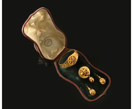 A late Victorian/Edwardian gold coloured metal suite of jewellery, comprising bangle, brooch and earrings in fitted case by G