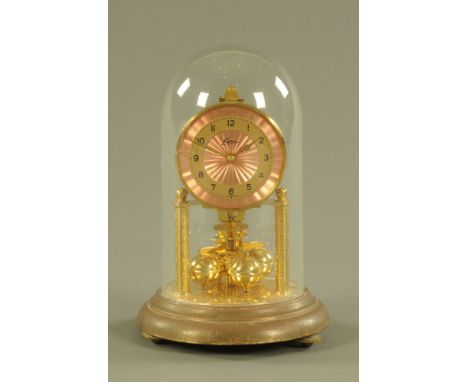 A brass anniversary clock, with pink dial and Arabic numerals under dome.  Overall height 22.5 cm. CONDITION REPORT: We have 