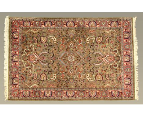 A Persian design carpet, with fringed ends, principal colours green, light blue, beige and red and with pink line border.  28