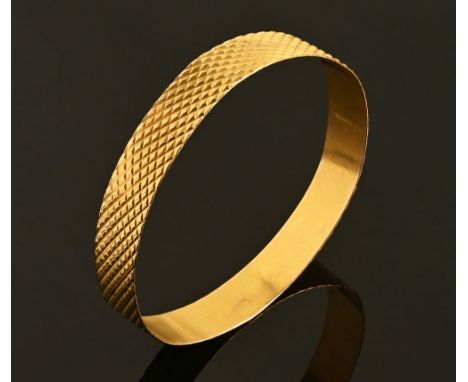 A gold coloured metal bangle, 24 grams.