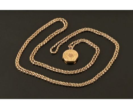 A 9 ct gold chain with yellow metal embossed decorated circular hair locket.  70 cm long. 29 grams gross.