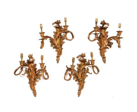 A set of four rococo style gilt metal two light wall light fittings.  Height 36 cm, width 28 cm. CONDITION REPORT: These four