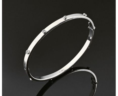 A 9 ct white gold bangle, set with small clear stones.  6.5 grams gross. CONDITION REPORT: The bangle is oval rather than com