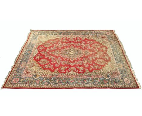 A large Persian design fringed carpet, principal colours red, blue, light blue and beige.  408 cm excluding fringe x 306 cm.