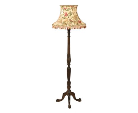 An Edwardian mahogany lamp standard, carved and reeded and raised on downswept legs terminating in claw and ball feet.