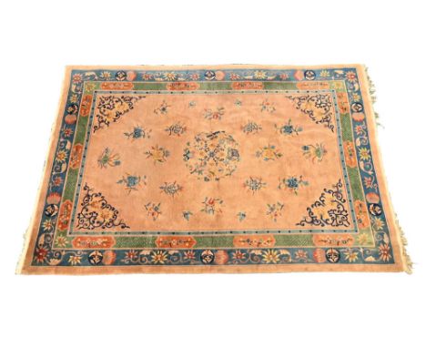 A Chinese rectangular carpet, with fringed ends, the centre rectangular panel beige with foliate designs and with repeating l