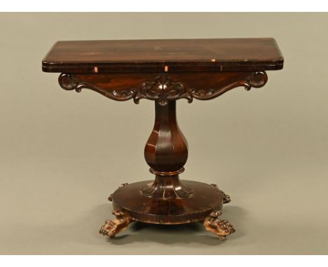 A Victorian rosewood turnover top card table, with scrolling mouldings to the frieze, the faceted column and circular base ra