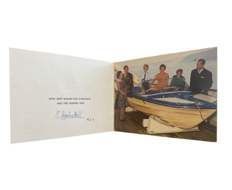 A 1969 Christmas Card from HM The Queen. The cover with two gilt embossed Royal cyphers; the interior with a photo of the Roy