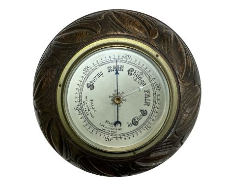 A 20th century wall barometer, round in carved wooden case. British Made. Diameter 23cm.