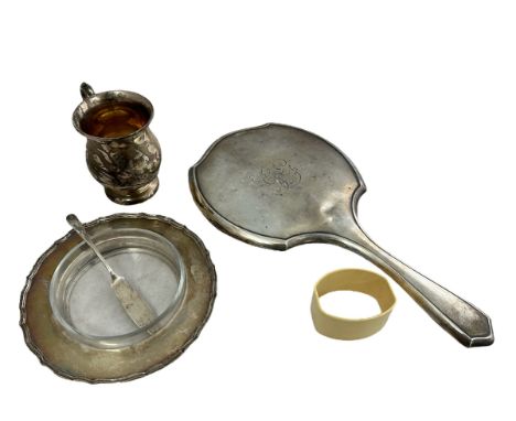 A silver handheld dressing mirror, a silver tankard, a butter dish with separate glass interior and a butter knife. All fully