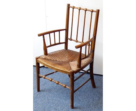 A late 19th century Morris-style Aesthetic Movement wooden armchair having rush seat and turned tapering legs united by a hig