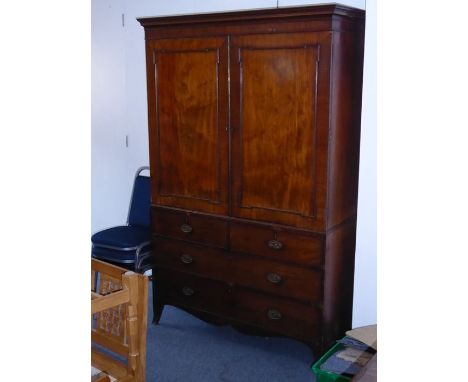 A late 18th century George III period mahogany linen press; the cornice above two panelled doors enclosing slides and further
