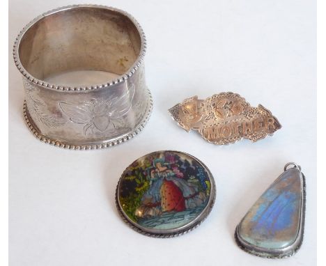 A small bijouterie group; to include a hallmarked silver napkin ring, an Edwardian silver 'Mother' brooch, a silver-backed br