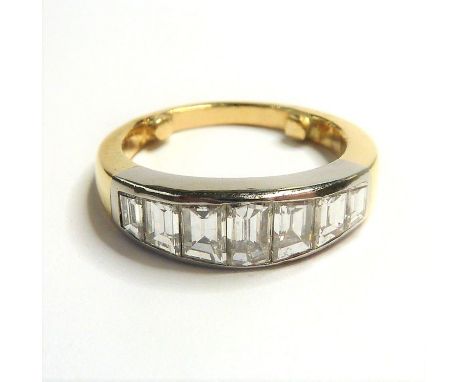 A seven-stone diamond ring; the graduated emerald-cut diamonds set in a line to the plain bi-coloured shank, two sizer pips a