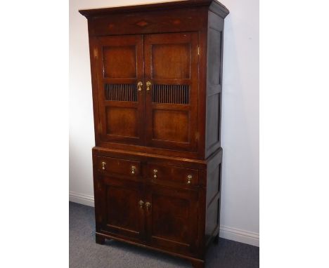 A good 18th century North Country-style oak food cupboard of slim proportions; outset cornice above a frieze inlaid with a ce