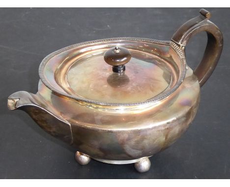 A hallmarked silver teapot; the recessed hinged lid below a gadrooned border and squat spherical body, raised on four ball-st
