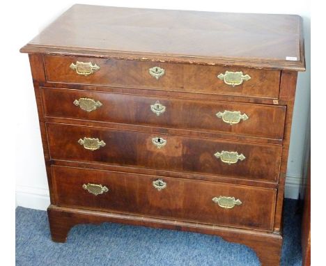 An early 18th century walnut chest; the quarter veneered chevron banded top with thumbnail moulding above, four full-width gr