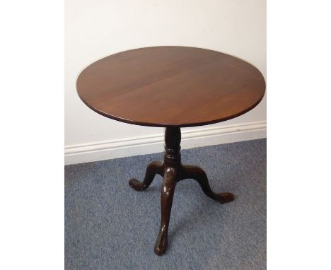 A George III period circular mahogany tilt-top occasional table; two piece top above turned stem and tripod base with elongat