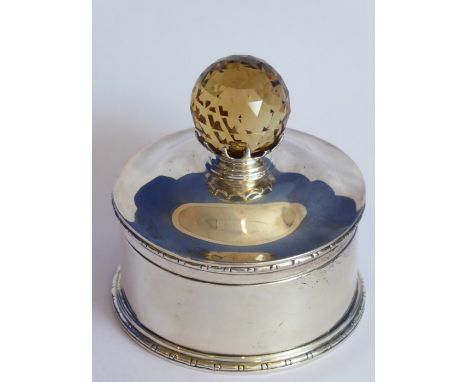 An Edwardian circular hallmarked silver box with hinged cover, the hand-cut finial (possible a smoky quartz) supported in a c