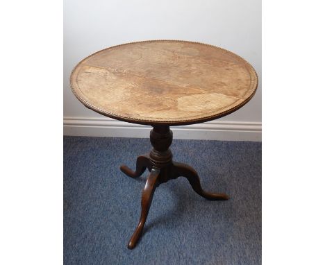 An early 19th century circular oak and dog-tooth banded tilt-top occasional table; turned stem with further dog-tooth inlay a