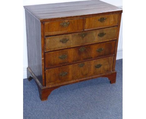 An early 18th century walnut and pine-sided chest; the cleated top above two half-width and three full-width drawers with D-s