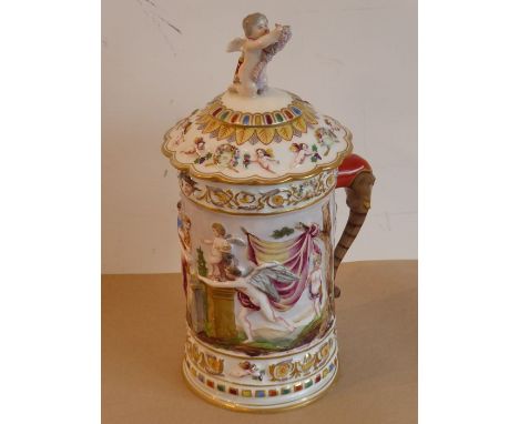 A unusual and large 19th century&nbsp;Capodimonte porcelain tankard and cover; the cover finial as a winged Cupid with a quiv