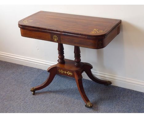 A Regency period rosewood and brass-inlaid fold-over top card table; the central frieze inlaid with a brass anthemion above t