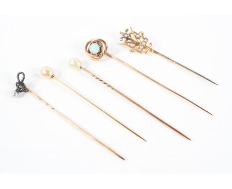 A collection of pins consisting of a knot pin with central opal and four pearl set pins of various designs. No hallmarks; tes