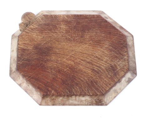 A Robert 'Mouseman' Thompson oak octagonal bread board, with moulded corners, carved to the side with a mouse, 30 cm wide 