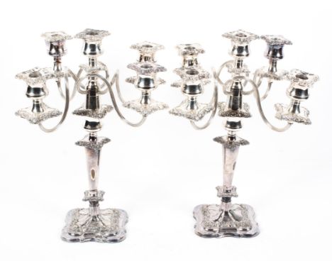 A pair of Victorian style silver plated five light candelebra, 20th century, each embossed with flowers and scrolls in neo-ro