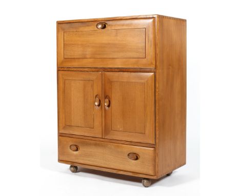 An Ercol blonde elm bureau cupboard, with fall front revealing a part fitted interior above a cupboard with double doors encl