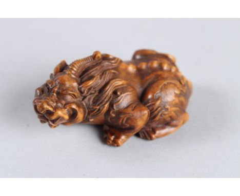 A CARVED WOOD HARDWOOD DRAGON NETSUKE. 3ins long.