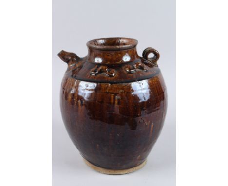 AN ISLAMIC BROWN GLAZE VASE with small handle and spout. 10ins high.
