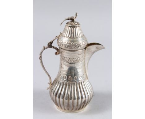 AN ISLAMIC WHITE METAL COFFEE POT, the lid with a bird. 7.5ins high.