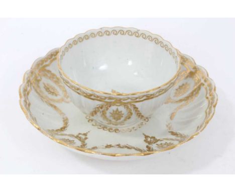 Worcester fluted tea bowl and saucer, circa 1775-80, decorated in gilt with swags and other patterns, the saucer measuring 14